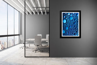 Framed artwork of blue bubbles on a gray wall in an office setting
