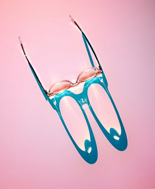 Blue sunglasses with rose gold frames on a pink background
