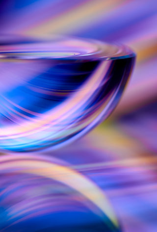 Close-up of a glass object with colorful, blurred light effects