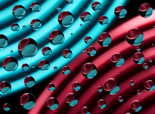 Abstract pattern of blue and red cylindrical shapes with water droplets on a diagonal