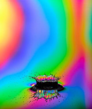Water droplet splash with rainbow refraction effect on a colorful gradient background