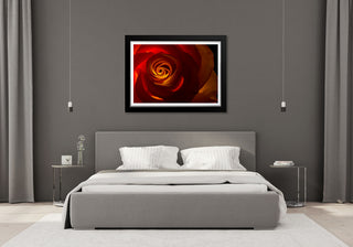 Bedroom with a gray bed and wall art of a red rose.