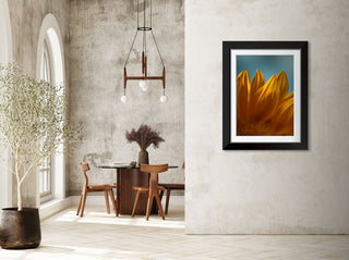 Framed sunflower artwork on a wall in a modern interior setting with a dining area.